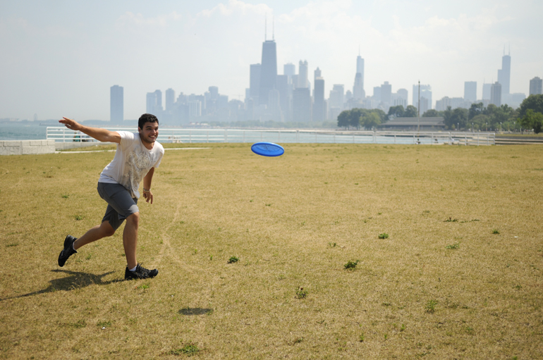 Artur throws a Frisbee on the shores of Lake Michigan in front of the Chicago skyline.