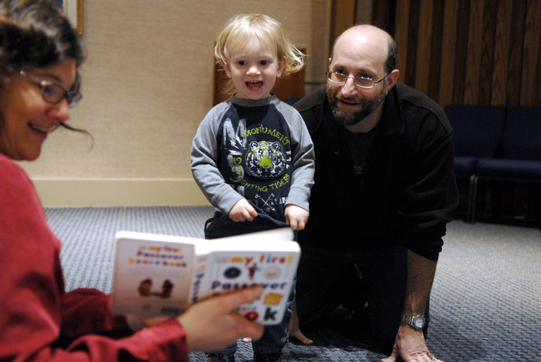 Agustin Wachs, age 1, listens to the Passover story as read by Elana Salzman with his father, Juan Wachs, during Parent-Tot Time on Sunday, March 17, 2013, at Temple Israel in West Lafayette. Passover, which celebrates the story of the Israelites\' escape from Egypt, begins at sunset on March 25.