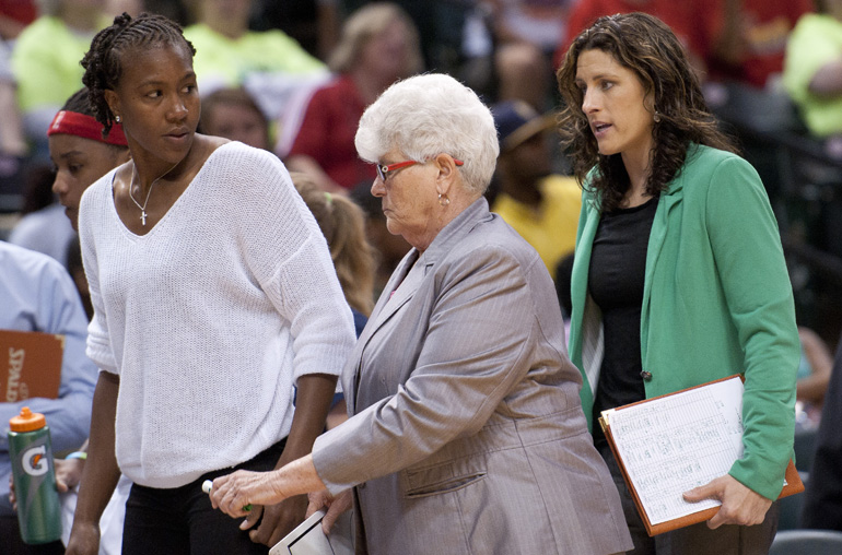 Fever forward Tamika Catchings, out with a sore back, walks back to the bench with Fever head coach Lin Dunn and assistant coach Stephanie White during the Indiana Fever\'s 107-102 overtime loss to the Tulsa Shock at Bankers Life Fieldhouse, Wednesday, June 25, 2014.
