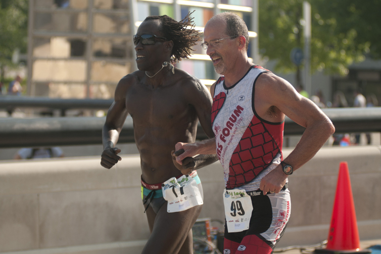 Runners cross the finish line together during the Tri-Indy Triathlon, Sunday, Aug. 3, 2014. The triathlon route was centered at White River State Park and went as far north as the Major Taylor Velodrome.