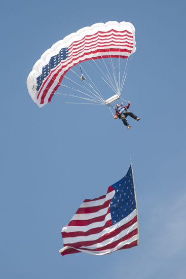 A parachuter brings the American flag down to the track before the women\'s Little 500 at Bill Armstrong Stadium in Bloomington, Friday, April 25, 2014.