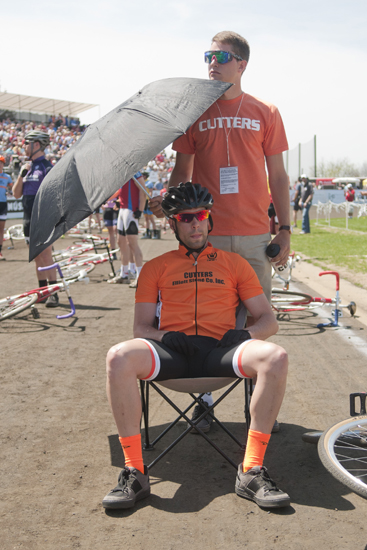 Cutters rider Brian Depasse sits under an umbrella next to his bike before the men\'s Little 500 at Bill Armstrong Stadium in Bloomington, Saturday, April 26, 2014.