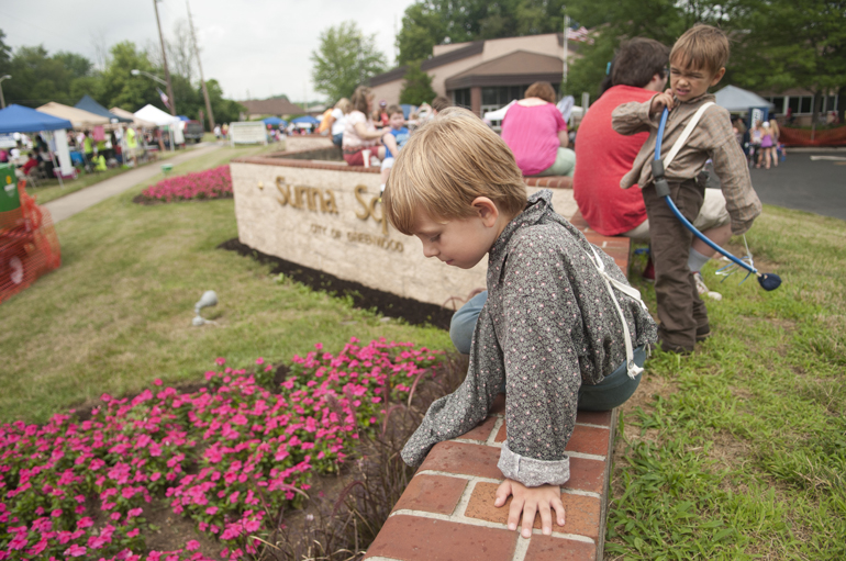 Greenwood Freedom Festival, Saturday, June 28, 2014. Michael and Owen Marsh, 6 and 4, play on a short wall overlooking a plot of flowers.