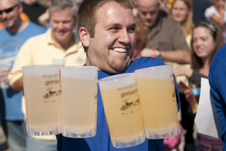 Jim Boosey of Schmitt & Associates tries to hold up four beer steins with outstretched arms during GermanFest at the Athenaeum in Indianapolis, Saturday, Oct. 12, 2013. Winners of this part of the Beer Games lasted longer than six minutes.