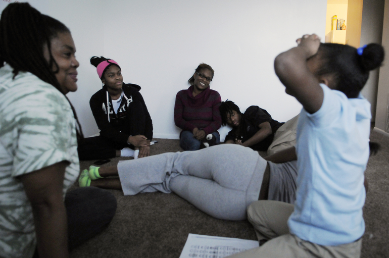 Peace Education Facilitator Naeemah Jackson of the Peace Learning Center and Denia, 16, Levia, and Jalen Heffner, 14, listen to Jazmine Heffner, 10, tell a story.