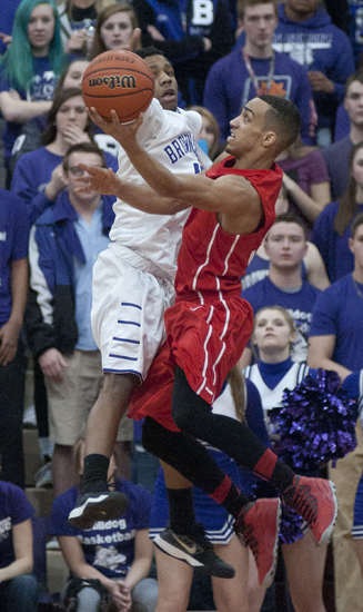 Richmond senior guard Isaiah Rader attempts to put up a shot around Brownsburg junior guard Michael Fowlkes during the Richmond boys\' basketball team\'s 71-65 victory over Brownsburg for the Southport Regional title at Southport High School, Saturday, March 14, 2015.