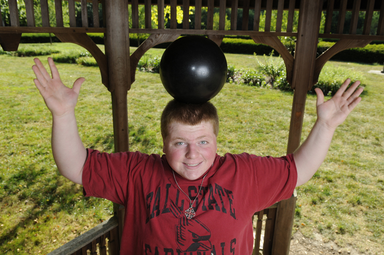 Craig Adams balances a bowling ball on his head for a quick second for a senior picture June 14, 2012, at Holcomb Gardens at Butler University in Indianapolis.
