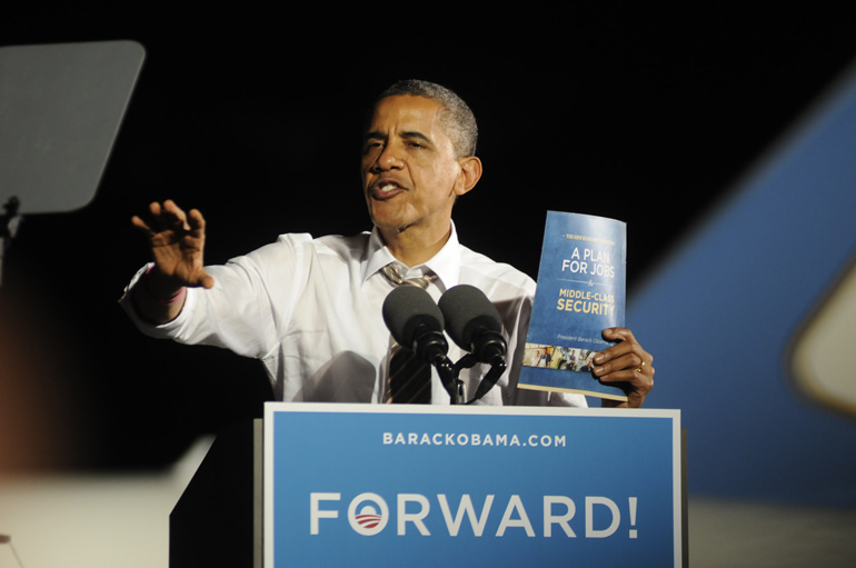 President Barack Obama shows off a booklet that explains his policy proposals for a possible second four-year term.