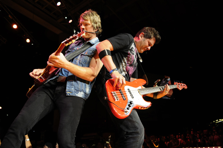 Rascal Flatts guitarist Joe Don Rooney, left, and bass player Jay DeMarcus perform during the trio's performance on Friday, Aug. 31, at Klipsch Music Center in Noblesville.