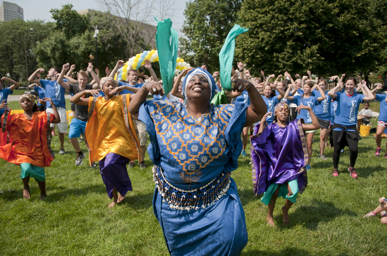 Sabra Logan, founder and director of Iibada Dance Company, leads walkers in an African welcoming dance during the third annual Walk for Water event downtown, Saturday, Aug. 2, 2014. The event raised money for a community clean-water well in Kager, Kenya. Attendees walked from American Legion Mall to the canal, filled buckets with water and walked back to the mall, simulating the path villagers without clean water have to take every day.
